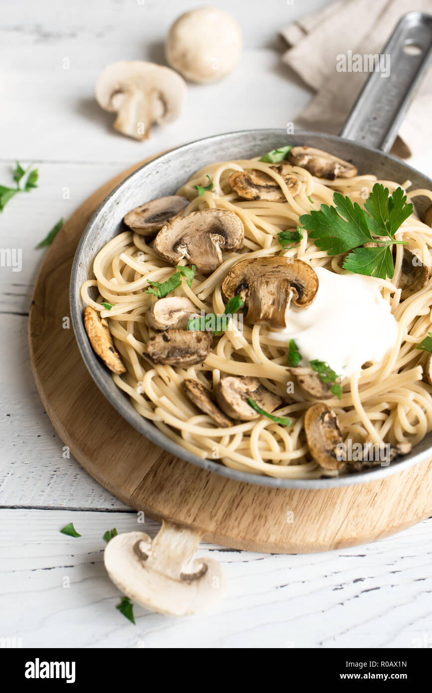 Pilz Spaghetti Pasta und Sauce auf weißem Hintergrund, Ansicht von oben. Hausgemachte italienische Pasta mit Champignon Pilze in der Küche pan. Stockfoto