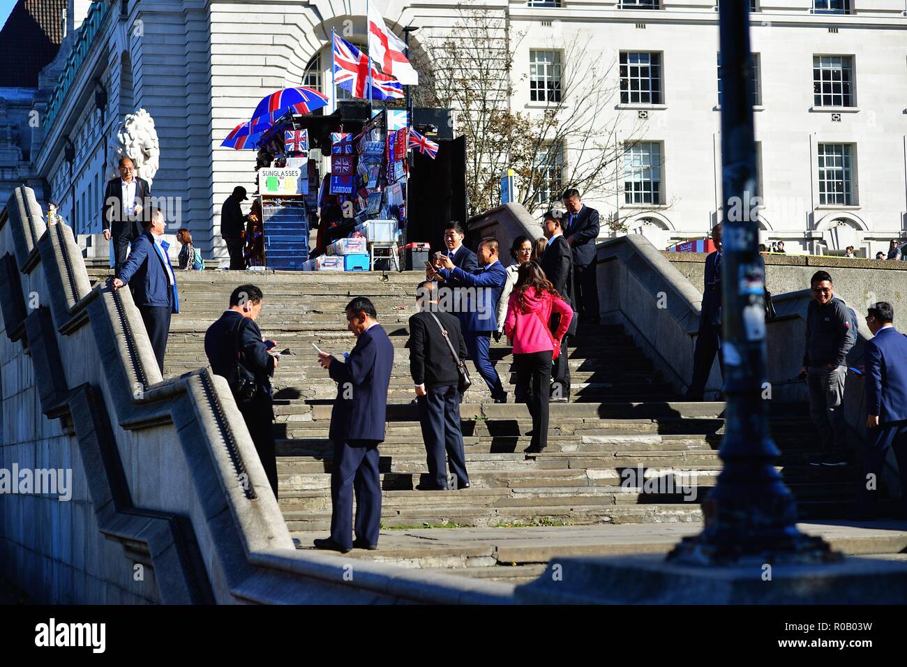 London, England, Vereinigtes Königreich. Eine Gruppe von asiatischen Touristen mit Handys Bilder mit den Häusern des Parlaments zu nehmen. Stockfoto