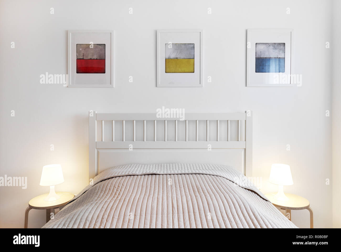 Innenraum der Schlafzimmer. Einfach, komfortabel und stilvoll. Lampen  Beleuchtung auf ein Bett, Tisch, Bett mit Wolldecke, Dekoration an der Wand  drei farbenfrohe Bilder Stockfotografie - Alamy