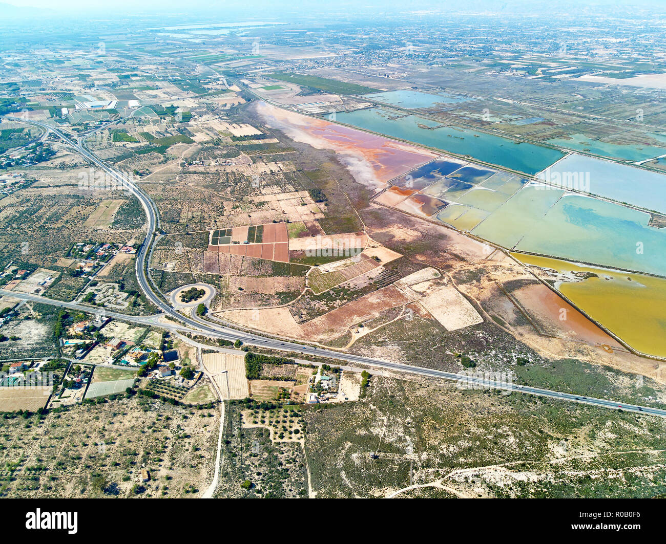 Antenne panorama Birds Eye View Autobahnen und Naturschutzgebiet von Santa Pola Salzseen. Drone foto Salzgewinnung sumpfige Gebiet Blick von oben. Torrevie Stockfoto