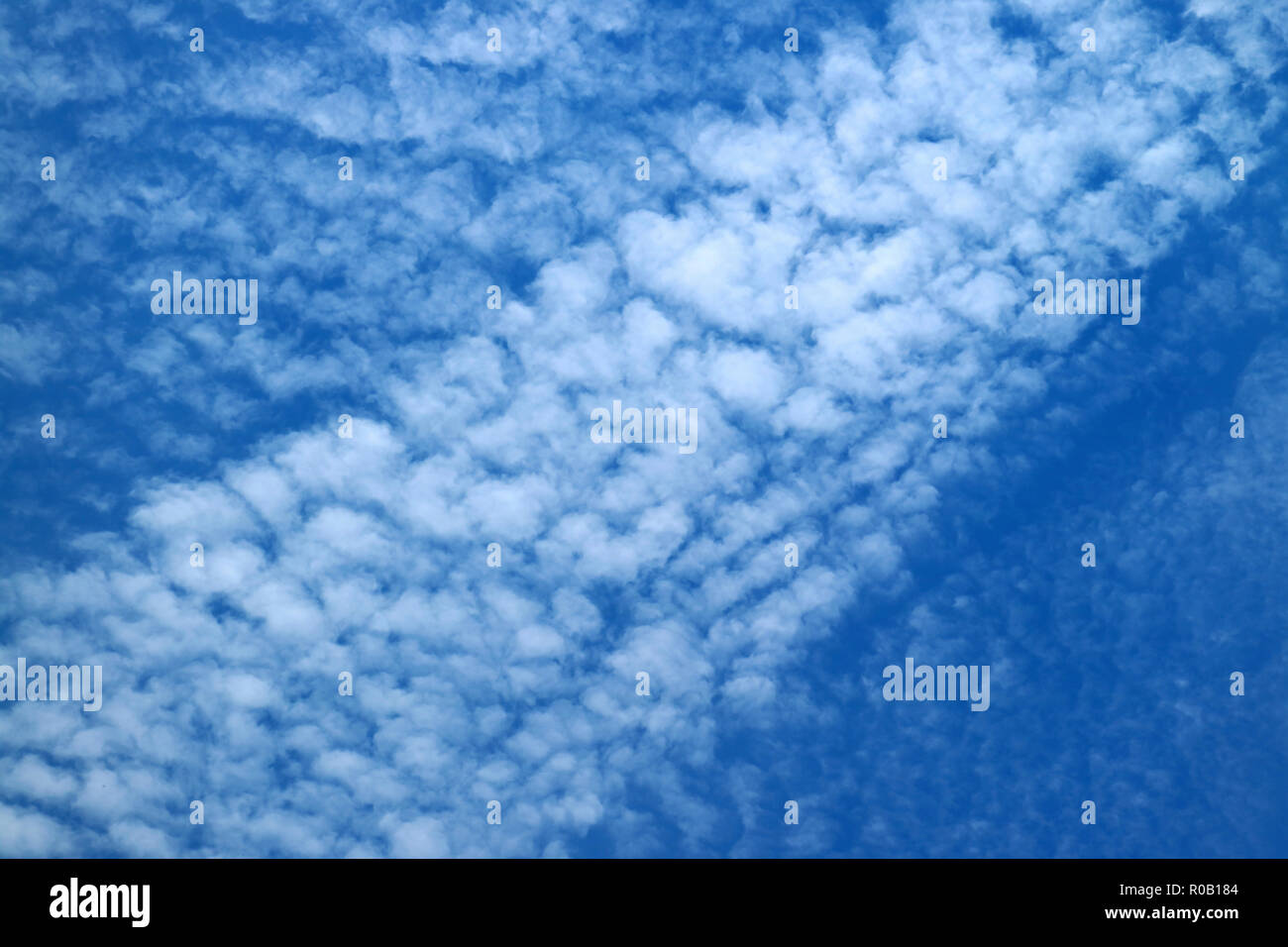 Weiß zerstreute Wolken am strahlend blauen Himmel Stockfoto
