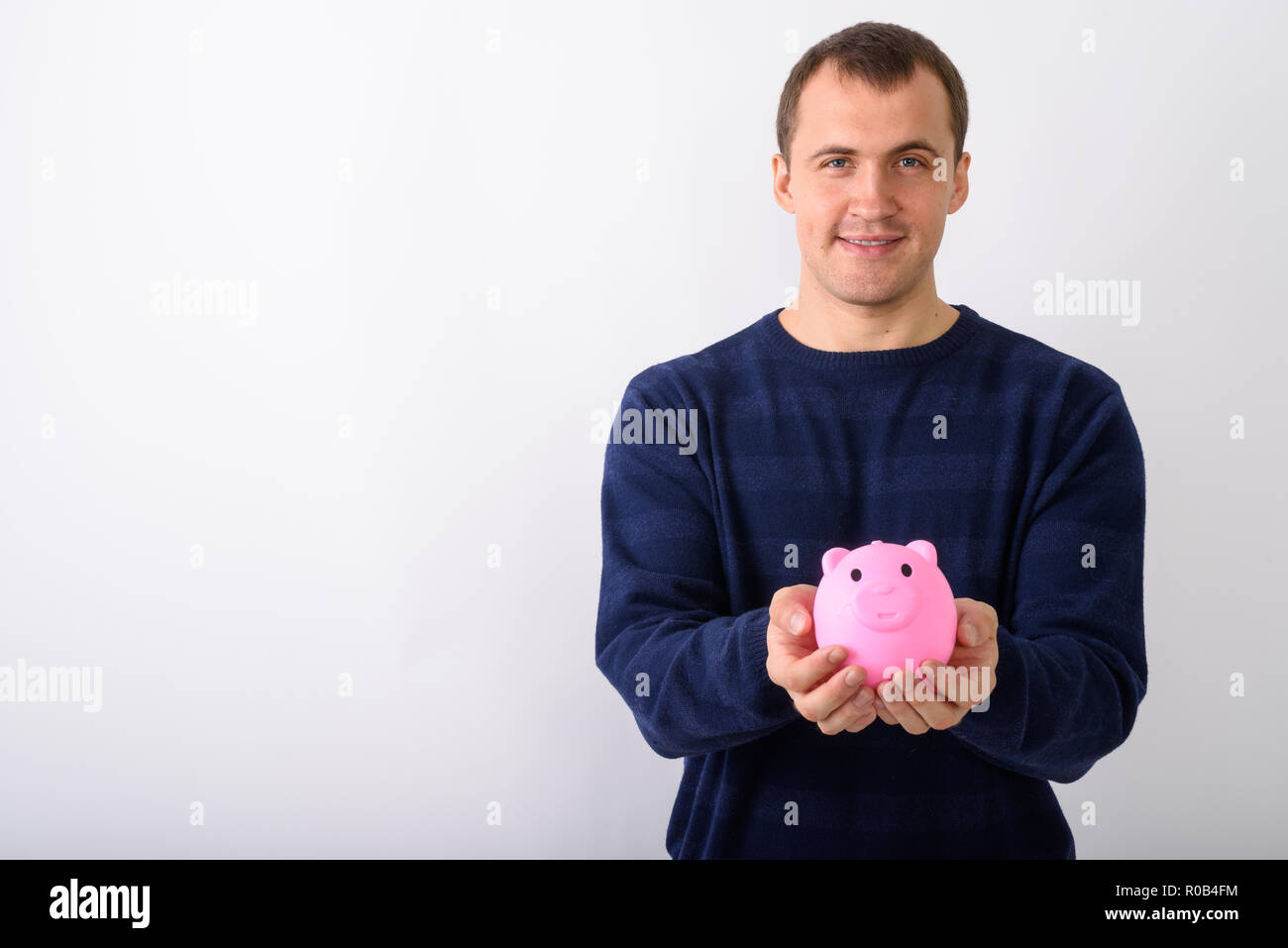 Studio shot der Jungen glücklich muskulöser Mann lächelnd, während pi-Holding Stockfoto