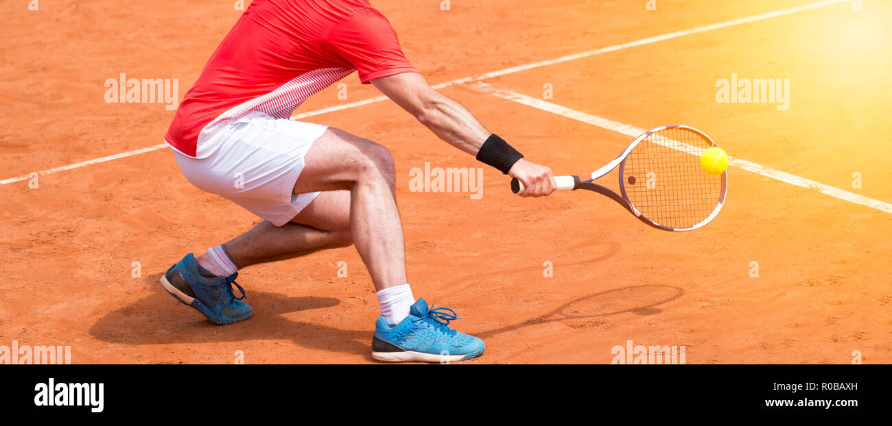 Mann spielt Tennis im Freien. Tennisspieler mit Schläger und Ball auf offenen Hof bei Sport Spiel Stockfoto