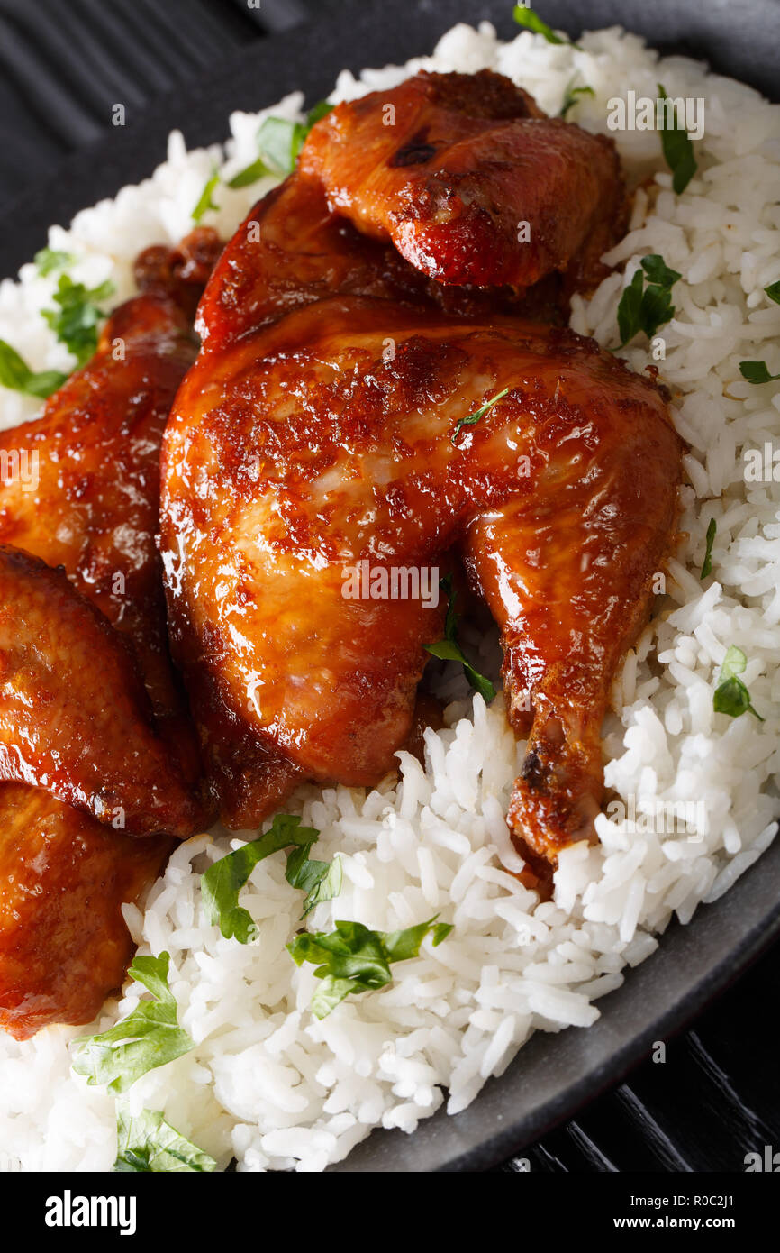 Indonesische Huhn gebacken in Ingwer Knoblauch Sauce serviert mit Reis auf einen Teller in Nahaufnahme. Vertikale Stockfoto