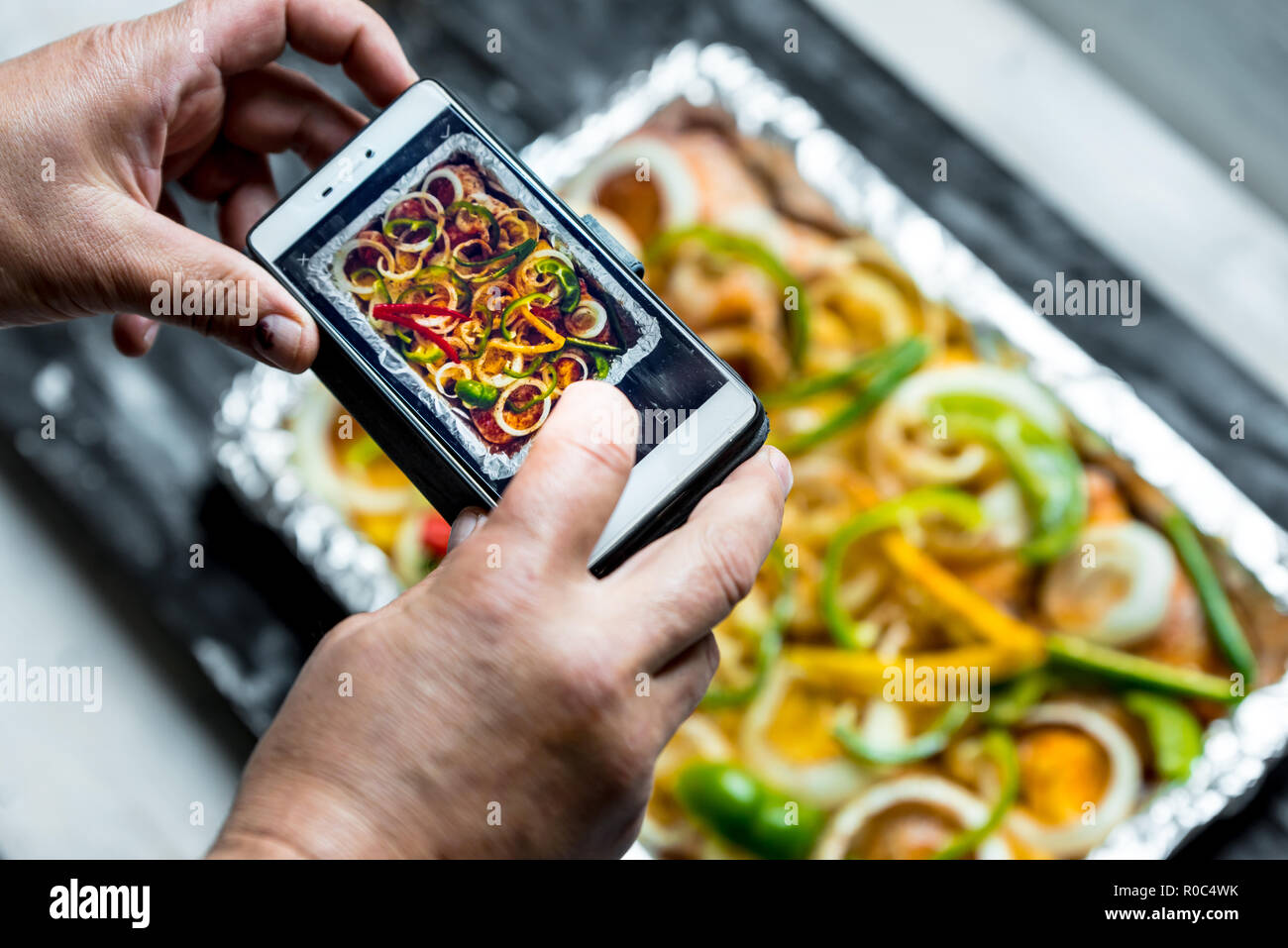 Die Person ist Fotografieren ein Lebensmittel mit einem Smartphone Stockfoto