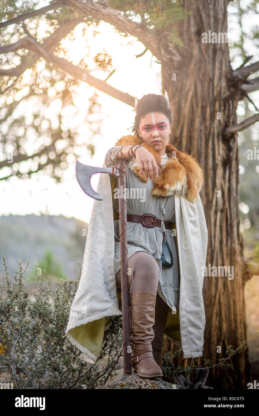Eine schöne weibliche Shield maiden Viking Charakter mit echten Pelz und eine Axt in die Berge. Fashion Editorial Einflüsse Stockfoto