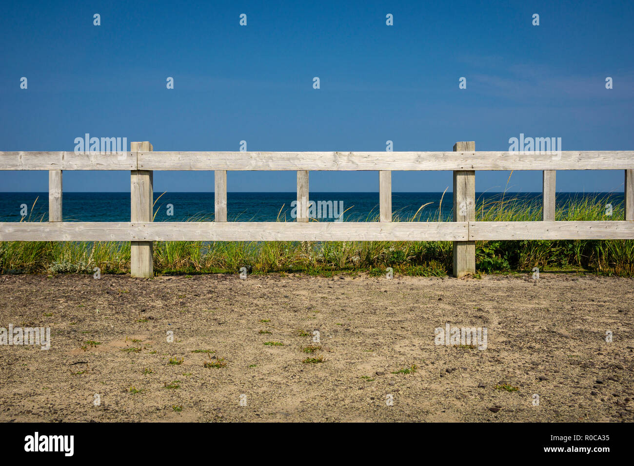 Holzzaun Barrikade entlang der Küste in Fatima am Schleifstein Insel, Magdalen Islands, Quebec, Kanada. Stockfoto