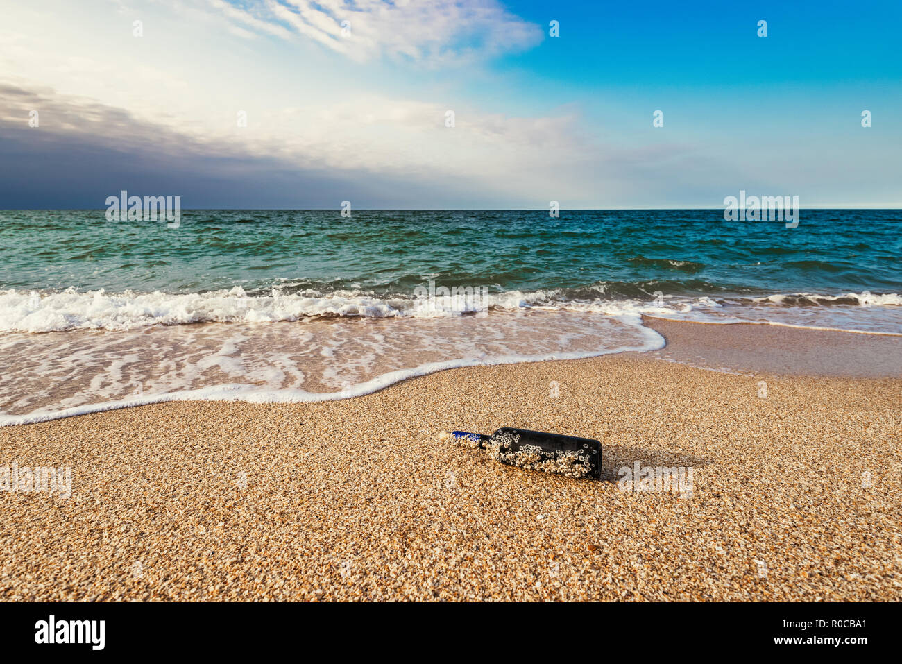 Eine Nachricht in einer Flasche mit korkgeschmack am leeren Strand Stockfoto