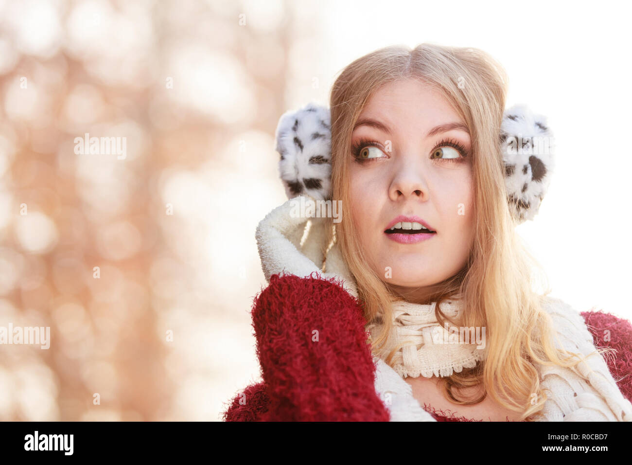 Portrait von Recht attraktive modische Frau im Herbst Forest Park. Wunderschöne junge Mädchen in Ohrenschützer und kastanienbraunen Pullover Pullover. Herbst Winter Art Stockfoto