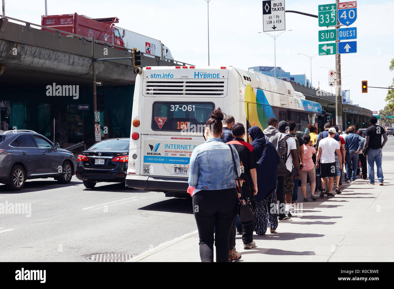 Menschen, die in der Warteschlange warten auf den öffentlichen Bus Station auf dem Bus in Montreal, Quebec, Kanada zu erhalten. Stockfoto