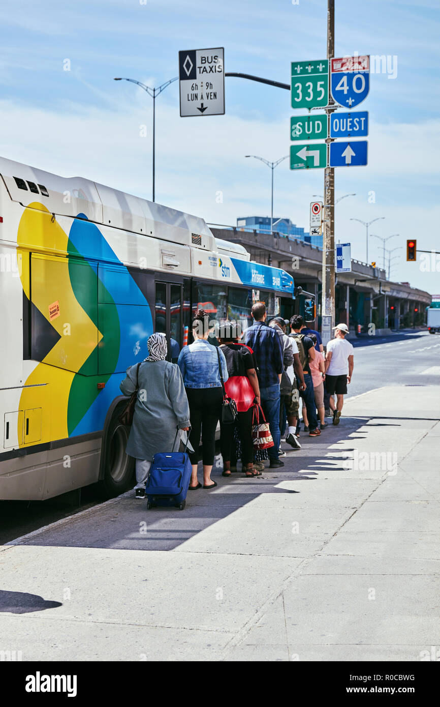 Menschen, die in der Warteschlange warten auf den öffentlichen Bus Station auf dem Bus in Montreal, Quebec, Kanada zu erhalten. Stockfoto