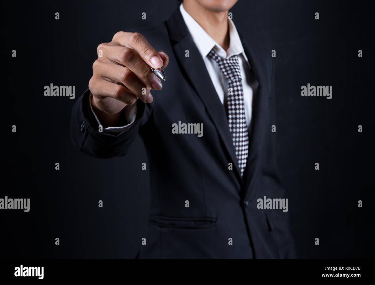 Geschäftsmann Hand halten Pen auf schwarzem Hintergrund. Wählen Sie Fokus Stockfoto