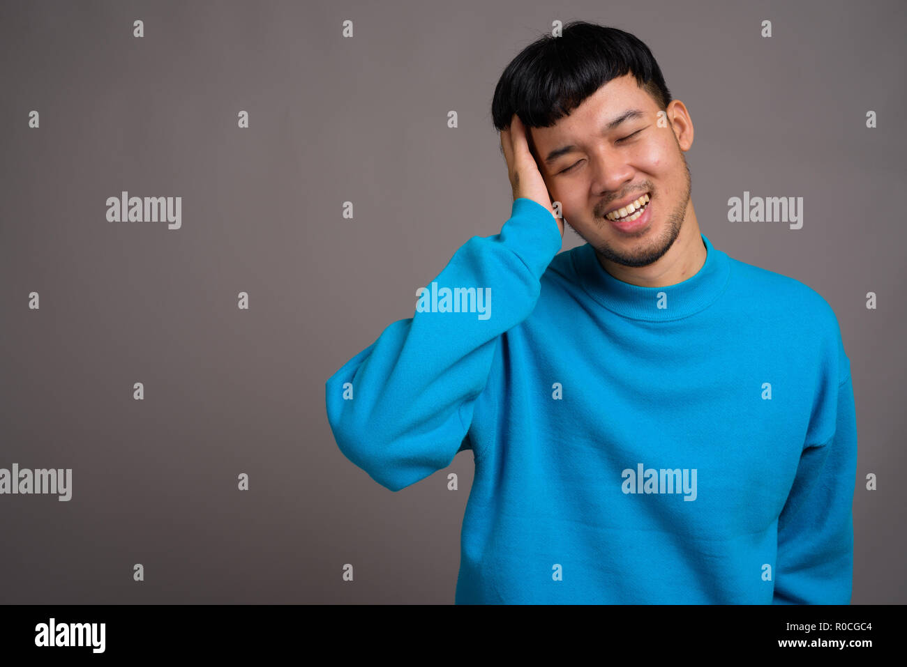 Portrait von jungen asiatischen Menschen gegen den grauen Hintergrund Stockfoto