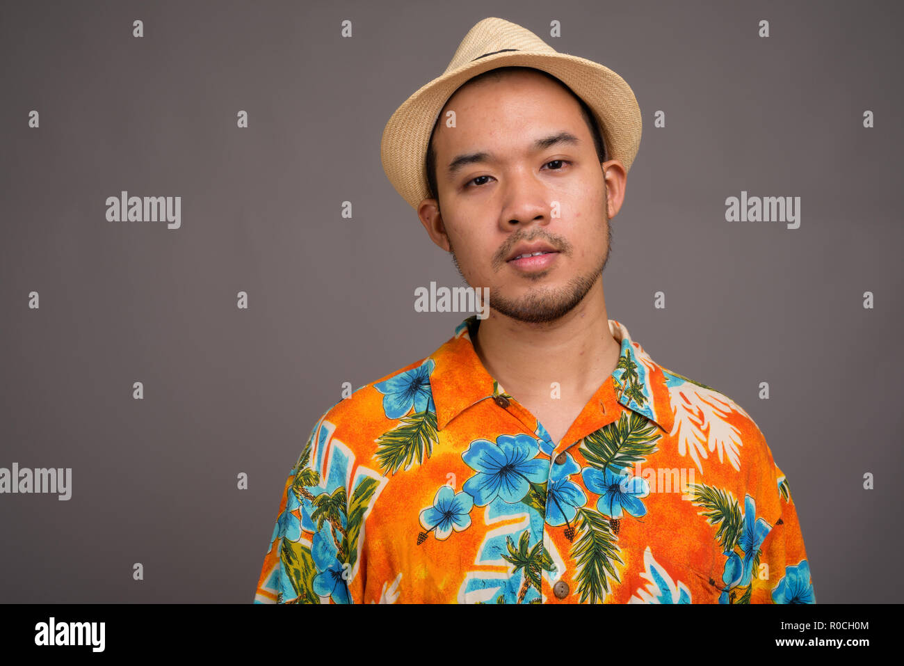Junge Asiatische tourist Mann bereit für Ferienhäuser gegen Grau backgrou Stockfoto