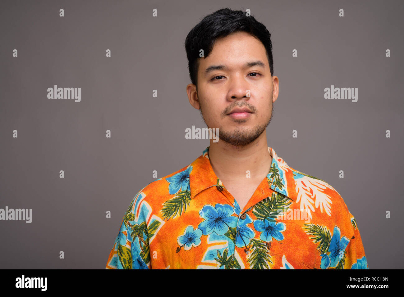 Junge Asiatische tourist Mann bereit für Ferienhäuser gegen Grau backgrou Stockfoto