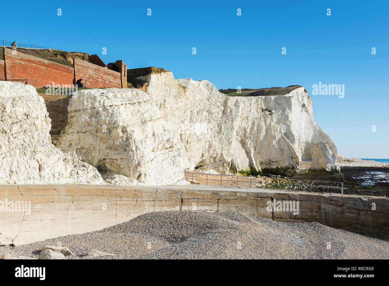 Zu Fuß zum Splash Punkt in Seaford East Sussex. England, Felsen, Meer und blauem Himmel, mit Blick auf die Überreste der Cliff Cottage oder Splash Point Hotel Stockfoto