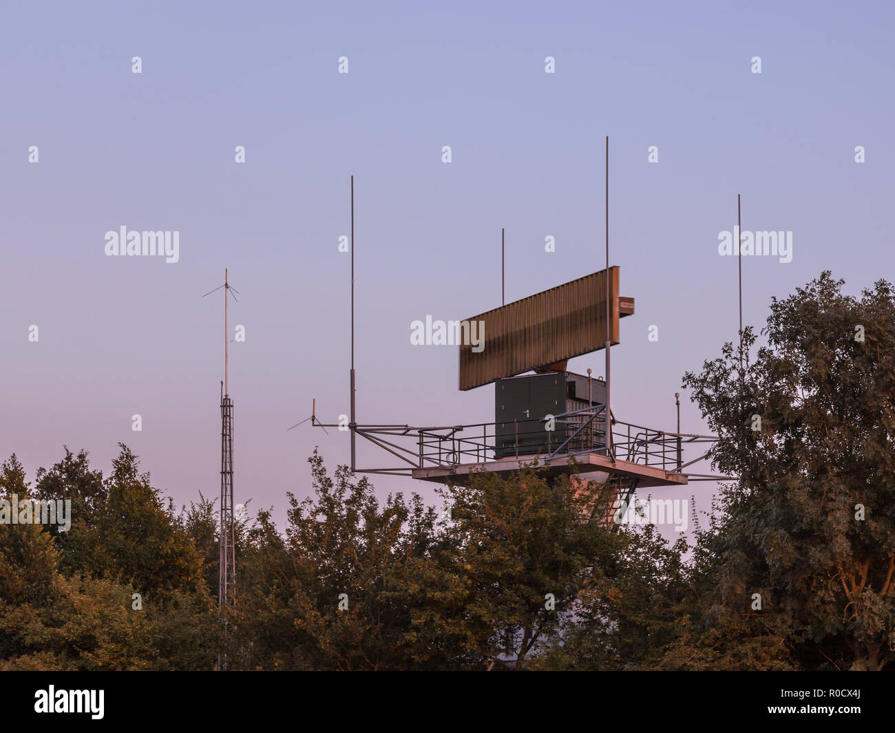 Flughafen Radarantenne Kommunikationstechnologie Netzwerk im Bush während des Sonnenuntergangs versteckt. Stockfoto