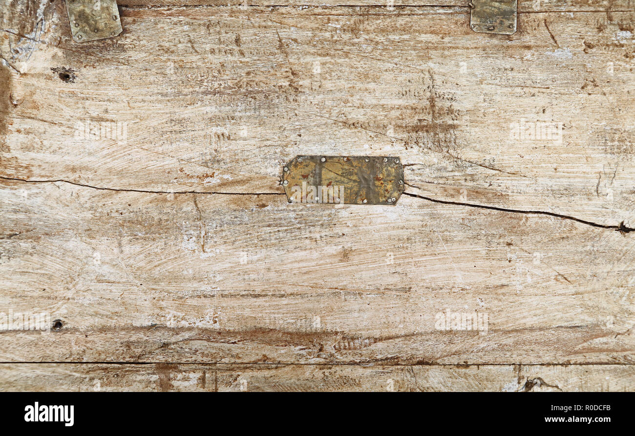 Grunge Hintergrund Textur aus weiß lackiertem Holz mit Dunkelbraun und Schwarz dirty Flecken, Kratzer, Risse und genagelt Zinnmetall patch Stockfoto