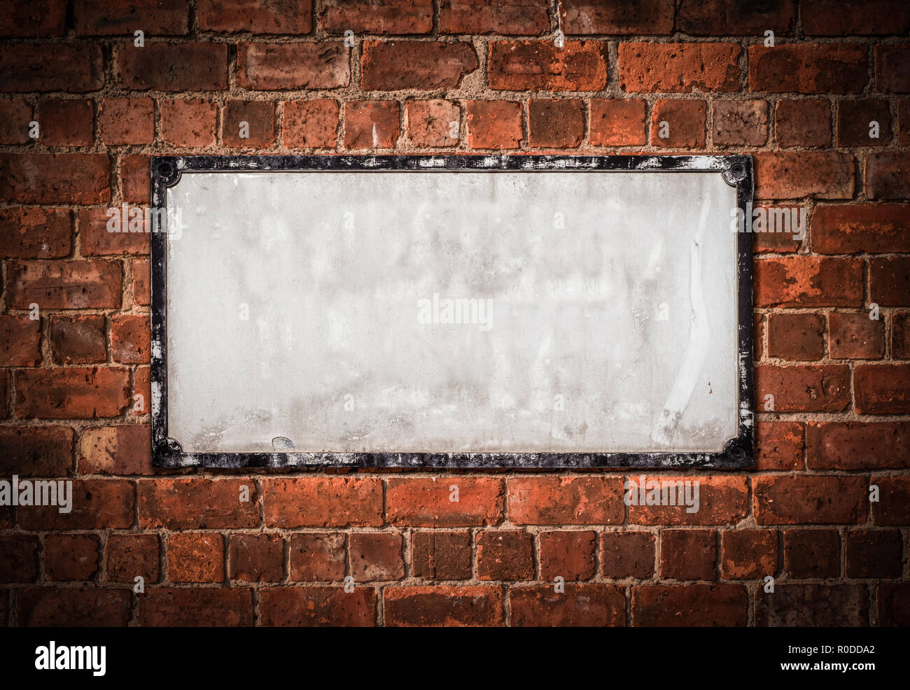 Grunge Alte leere weiße britische Straßenschild auf einem Red Brick Wall Stockfoto