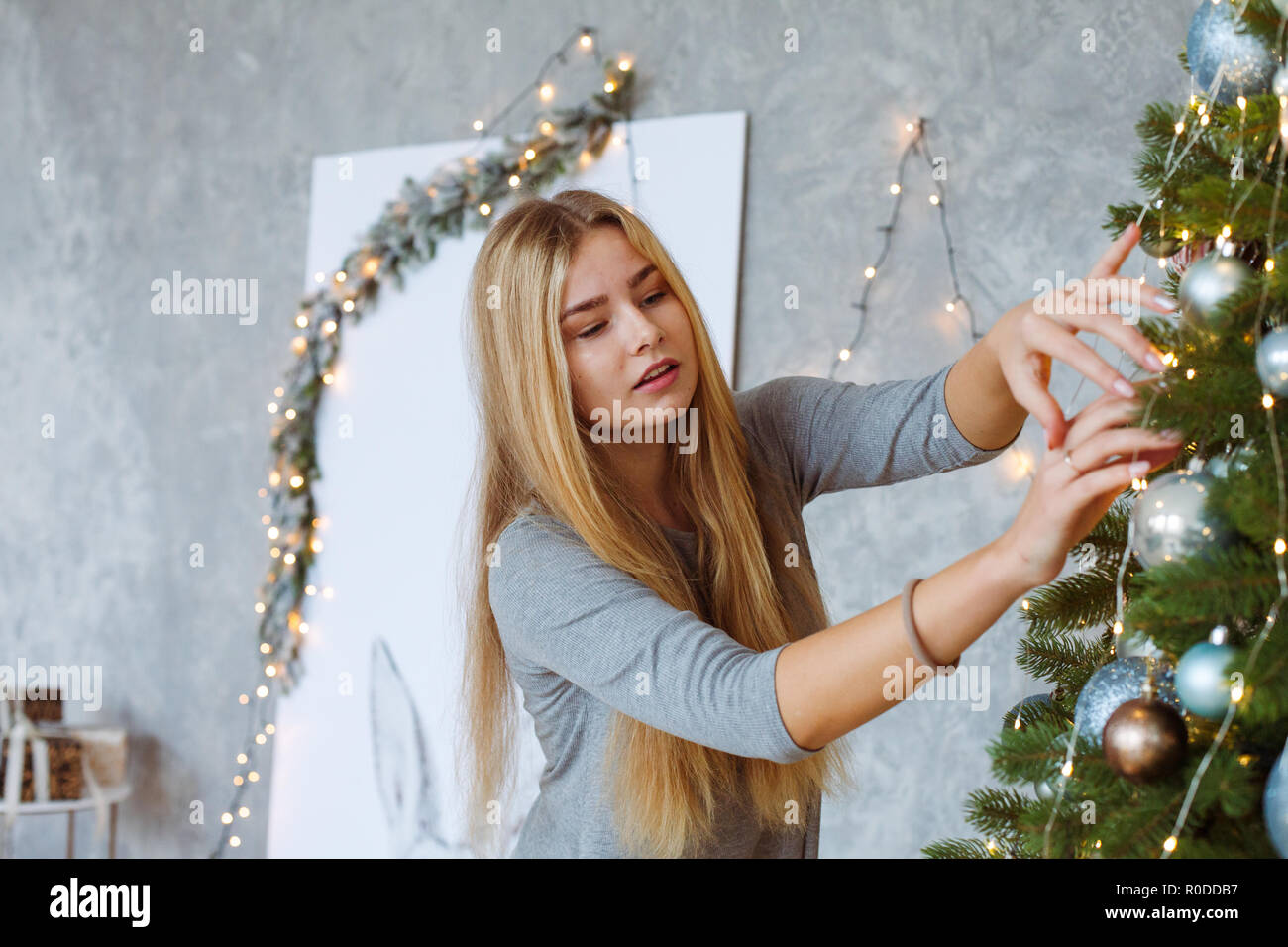 Junge Frau dekorieren Weihnachtsbaum Stockfoto