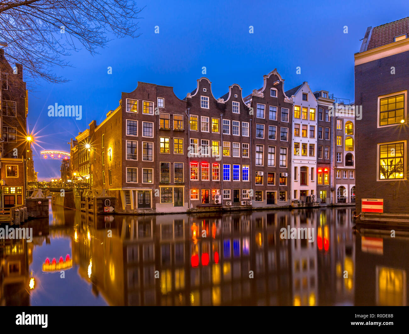 Traditionelle bunte canal Häuser in der frühen Nacht während der Blauen Stunde vom Sint Olofsteeg gesehen auf dem Oudezijds Voorburgwal im UNESCO-Worl Stockfoto