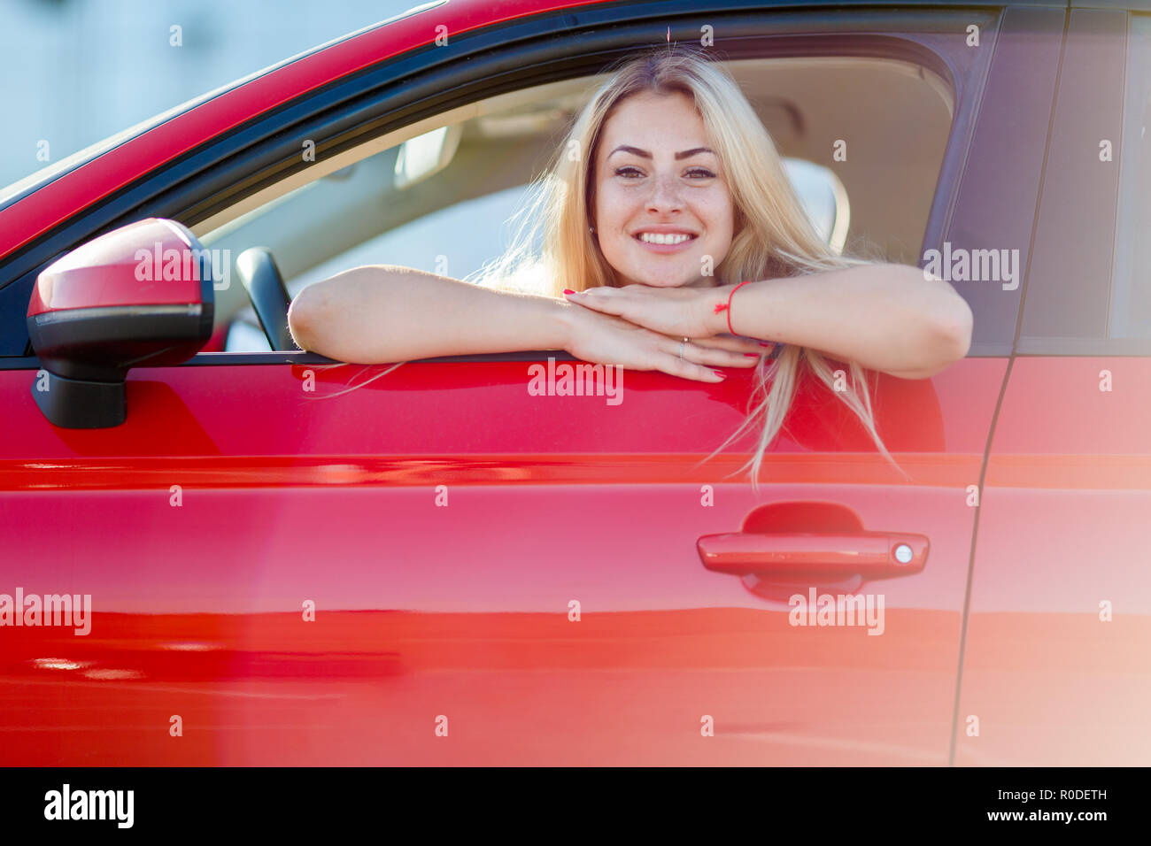 Foto des blonden Jungen sitzen in rotes Auto Stockfoto