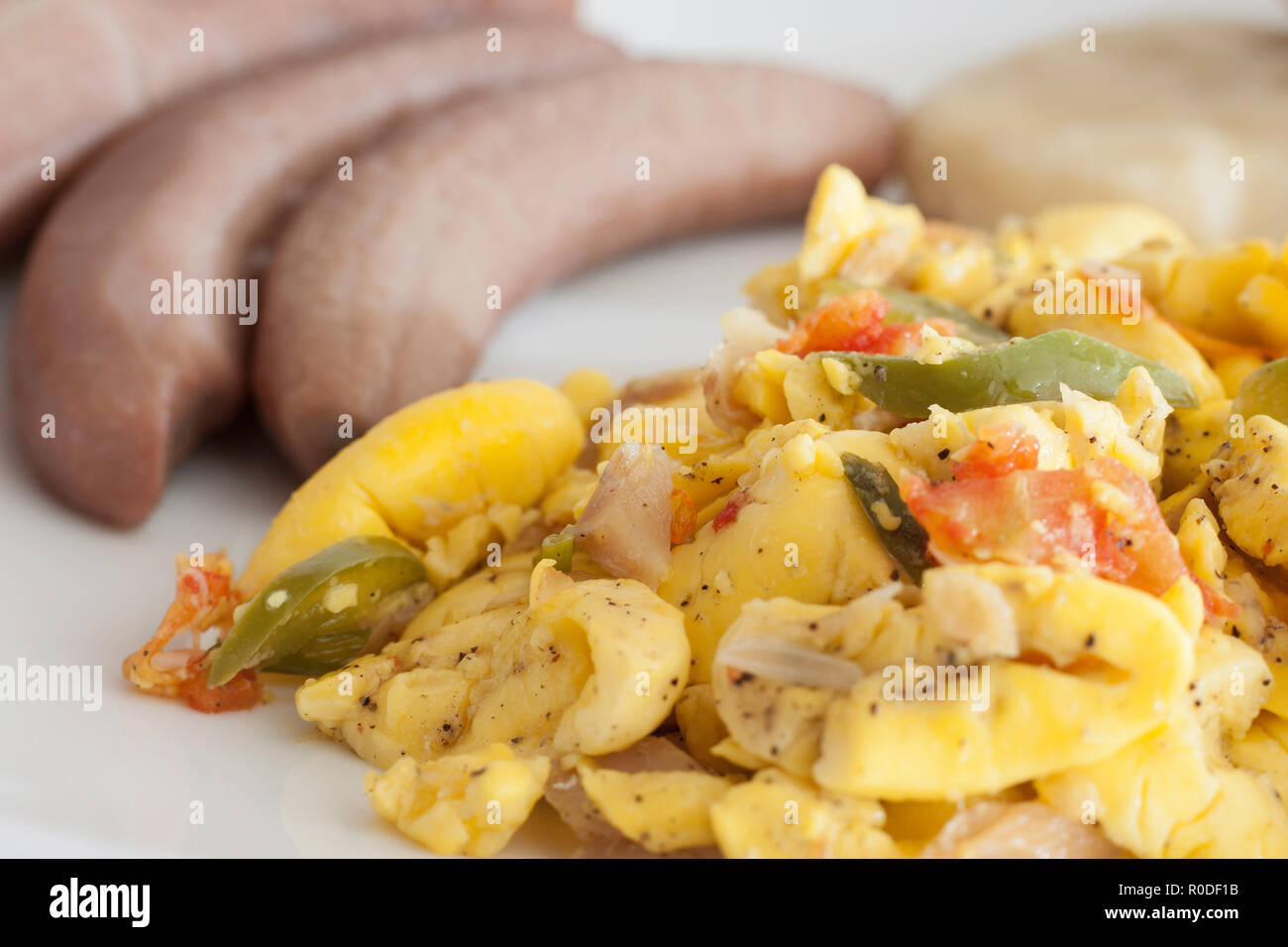 Ackee und Salz Fisch mit gekochten Bananen und Knödel auf einem weißen Teller serviert Stockfoto