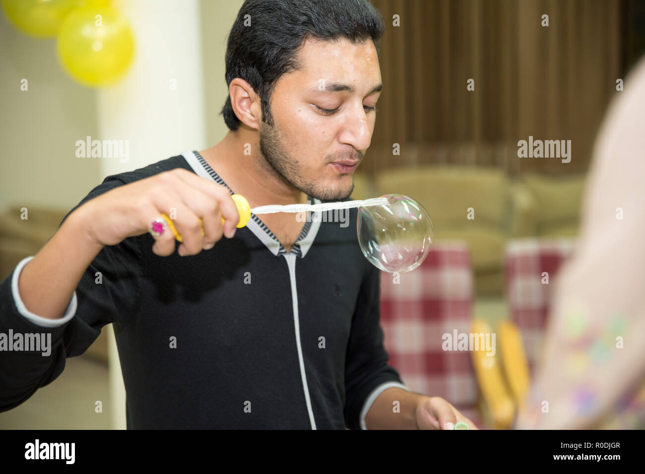 Ein junger asiatischer Boy bläst Wasser Blasen zu machen Stockfoto