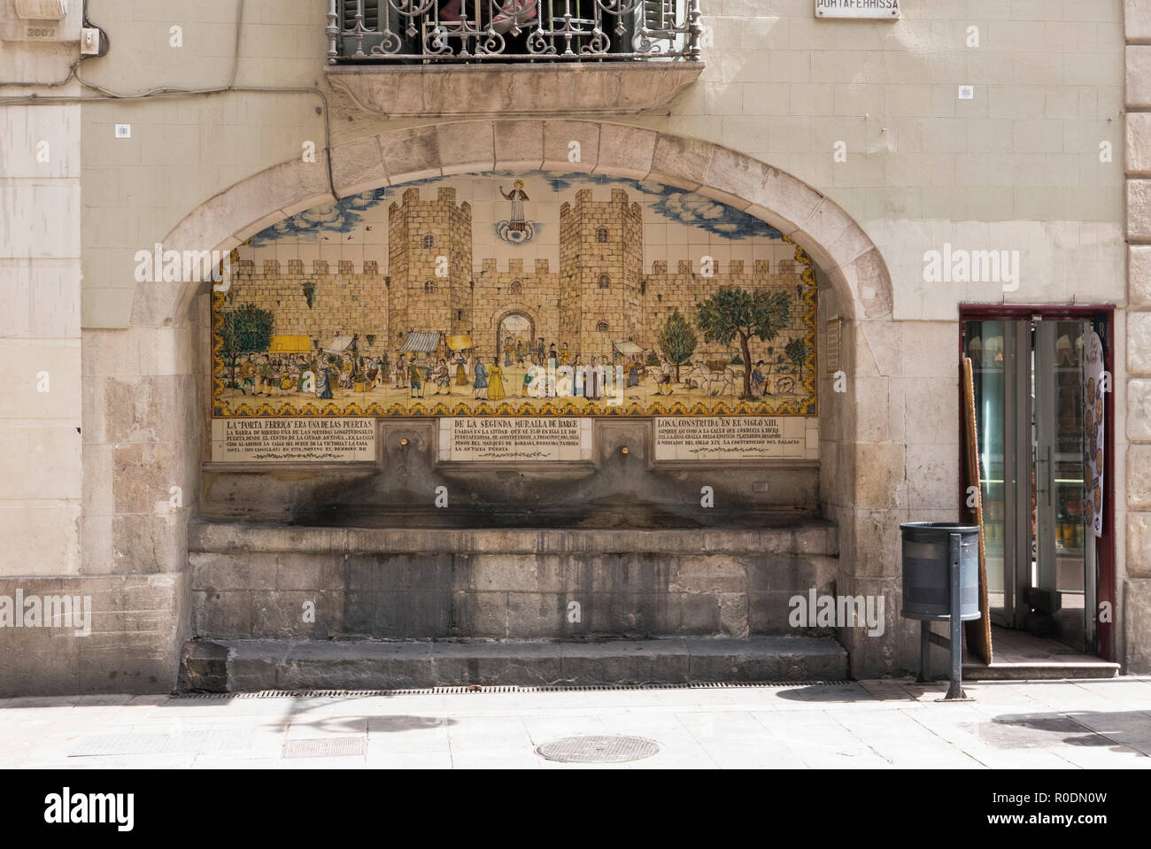 Ein alter Brunnen mit einem Wandgemälde über dem Taps, Las Ramblas, Barcelona, Spanien Stockfoto