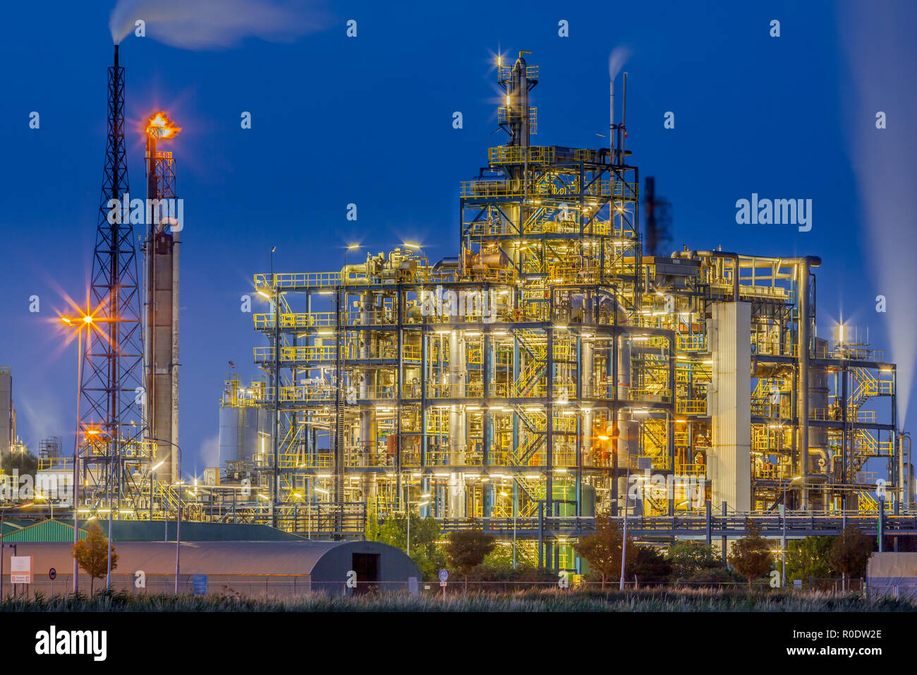 Nachtaufnahme der industriellen chemischen Anlage Rahmen mit einem Labyrinth von Rohren und Leitungen während der Dämmerung Stockfoto