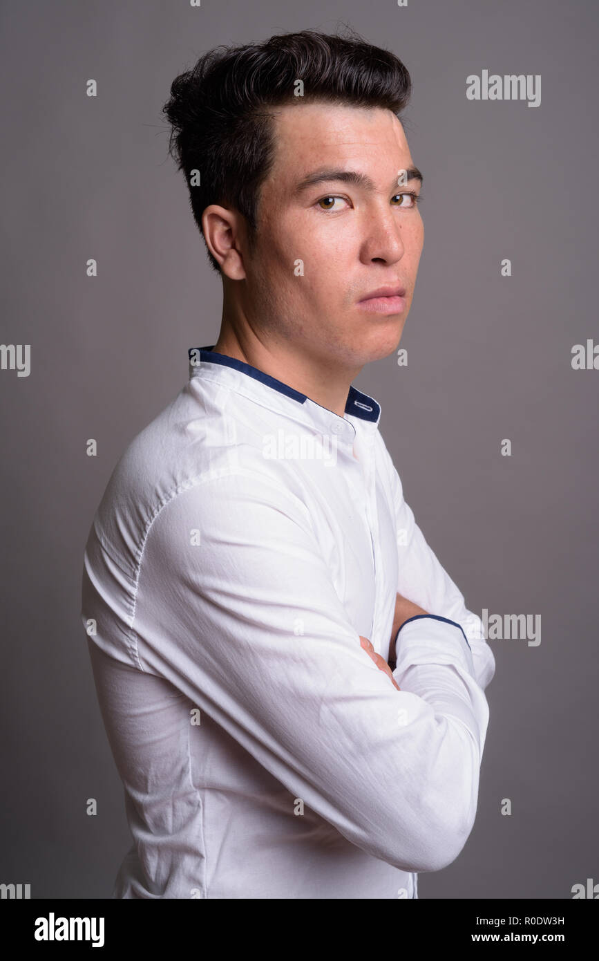Portrait von jungen asiatischen Geschäftsmann gegen grauer Hintergrund Stockfoto