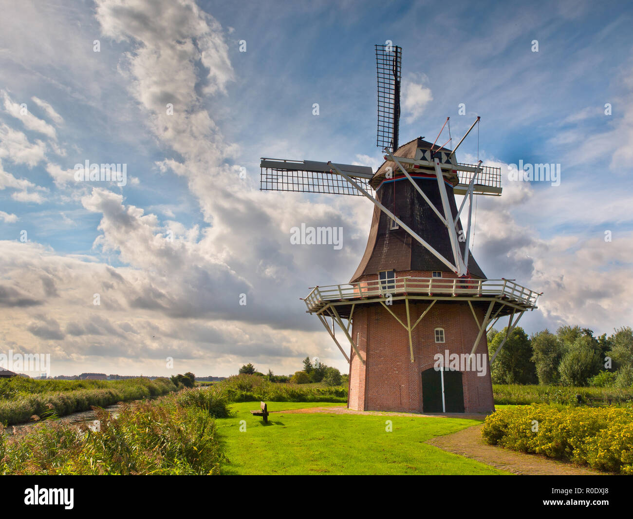 Alten historischen holländischen Windmühle neben einem Kanal im ländlichen Landschaft Stockfoto