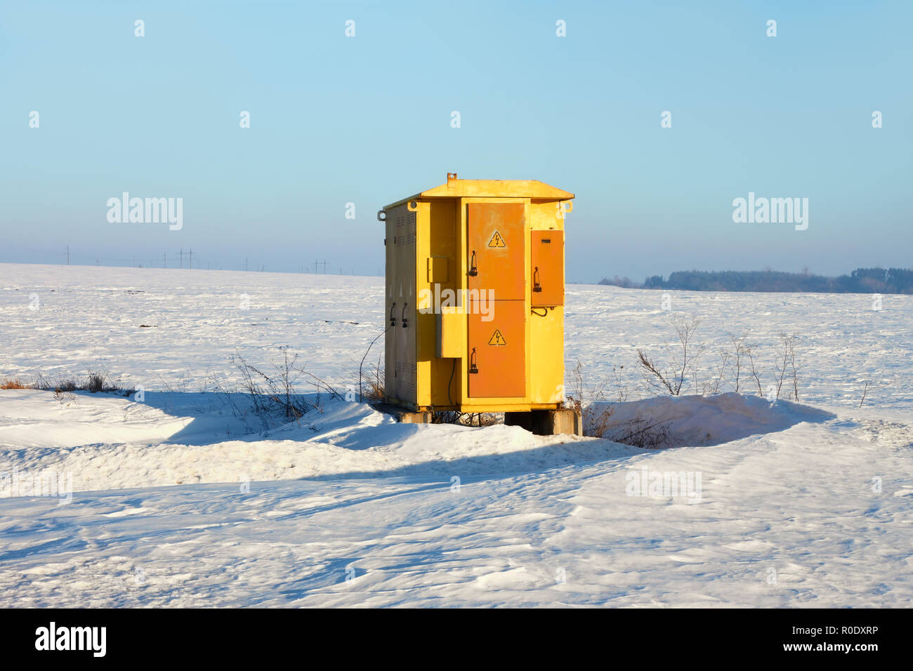 Alte elektrische Anlage Umspannwerk unter schneebedeckte Felder an einem schönen Wintertag Stockfoto