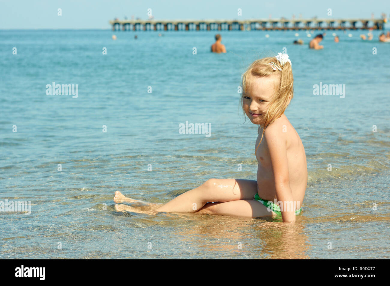Kleines Mädchen auf das türkisfarbene Meer Wasser in flachen Küstenstreifen in der Nähe der Birne Stockfoto