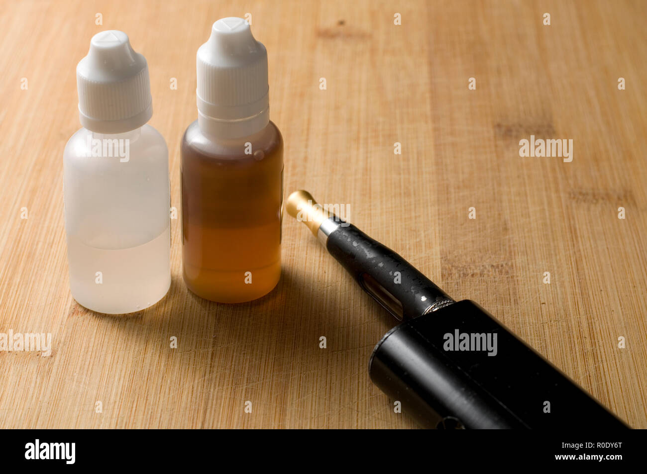 elfbar elfa kaufen Schwarz Vaping Gerät mit Flaschen Flüssigkeit auf Holz Tisch  Stockfotografie