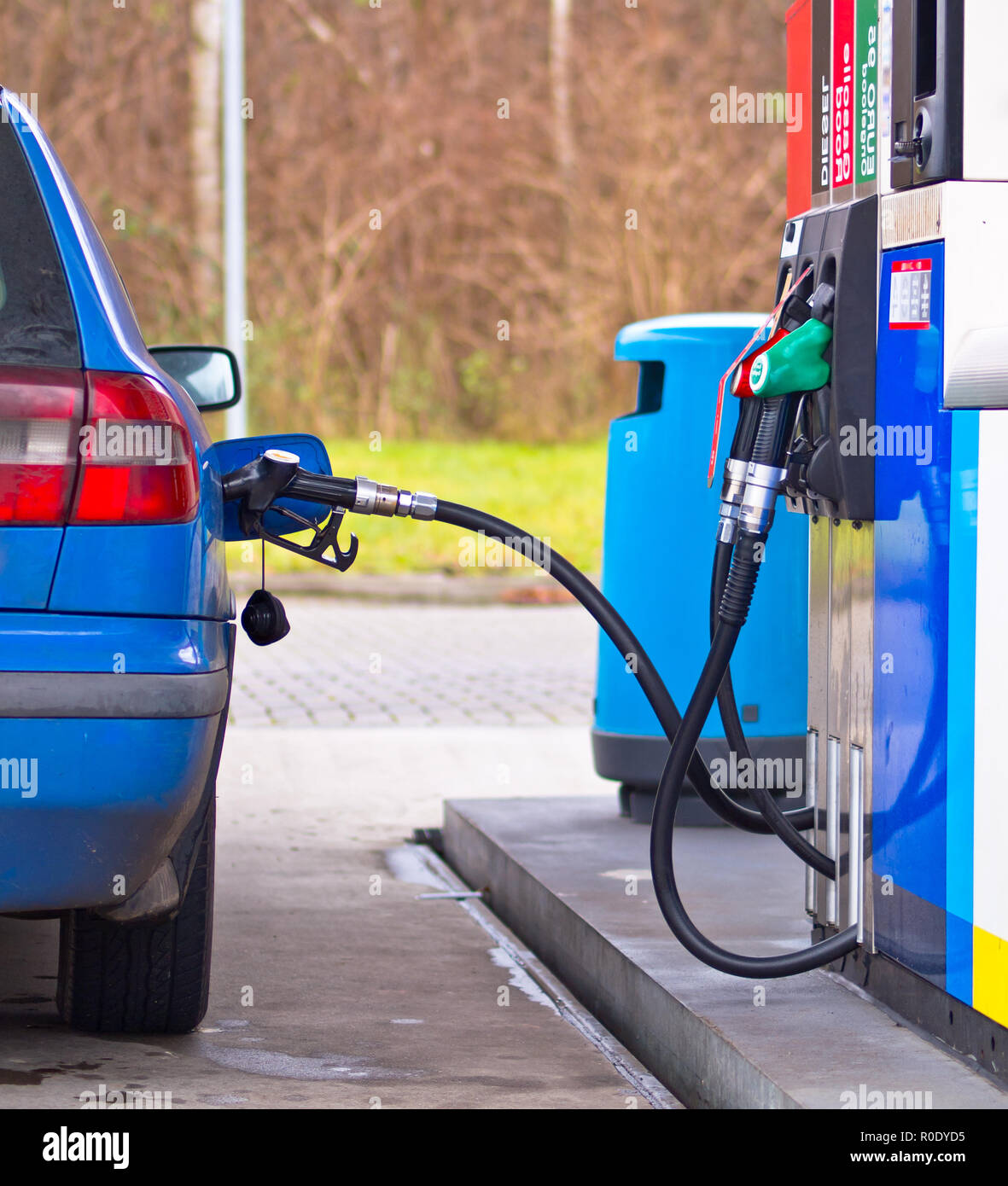 Blaues Auto an der Tankstelle mit Kraftstoff gefüllt werden, gegen überhöhte Preise Stockfoto