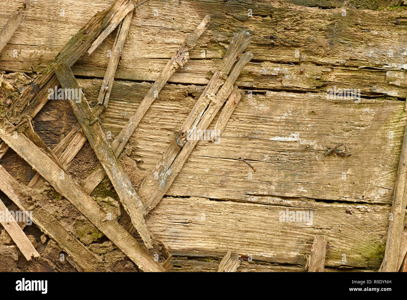 Detail einer alten verfallenen Holzwände. Holzlatten werden verwendet, wie es sich mit Schlamm Stockfoto
