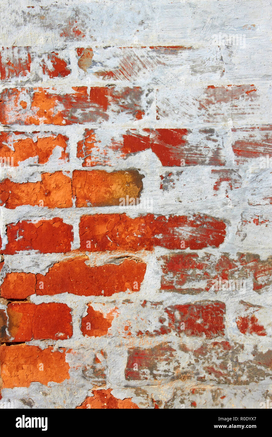 Alte Mauer aus rotem Backstein teilweise durch Zement bedeckt gemischt mit Kalk Stockfoto