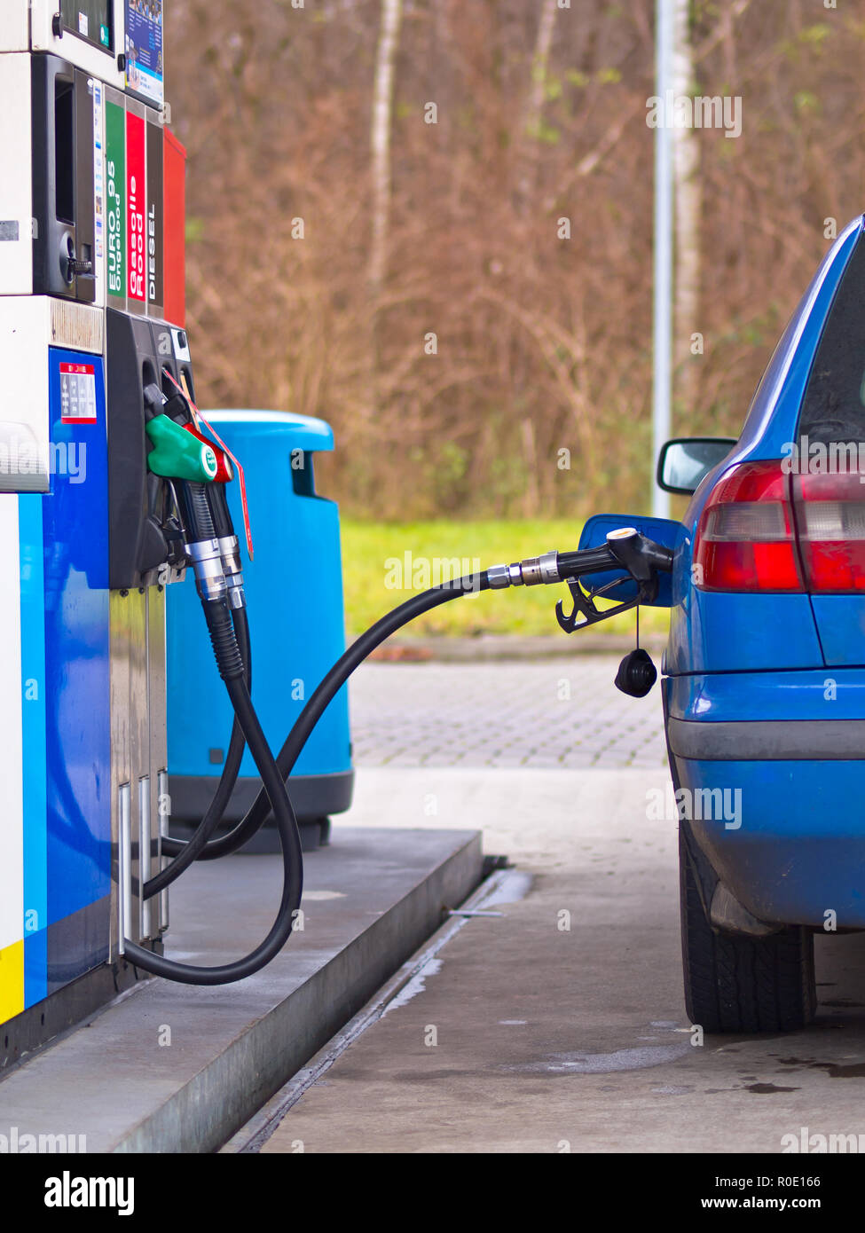 Blaues Auto an der Tankstelle mit Kraftstoff gefüllt werden, gegen überhöhte Preise Stockfoto