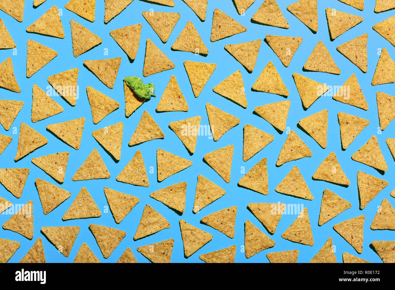 Hohe Betrachtungswinkel von Tortilla Chips auf blauem Hintergrund, einen Chip hat Guacamole Stockfoto