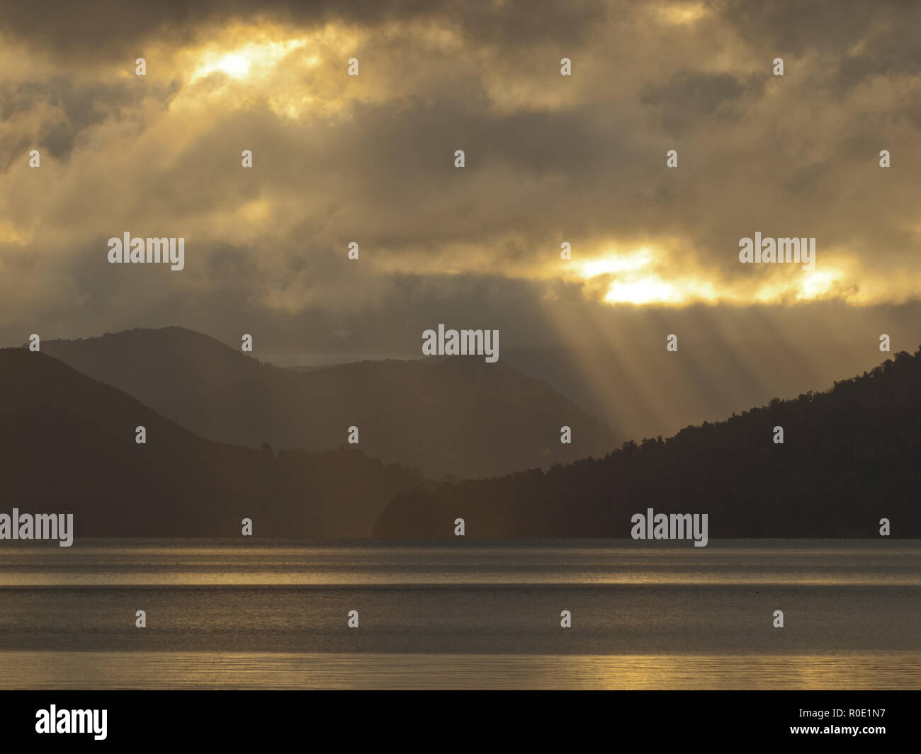 Sonnenstrahlen Strahlen durch die Wolken über dem See waikaremoane Stockfoto