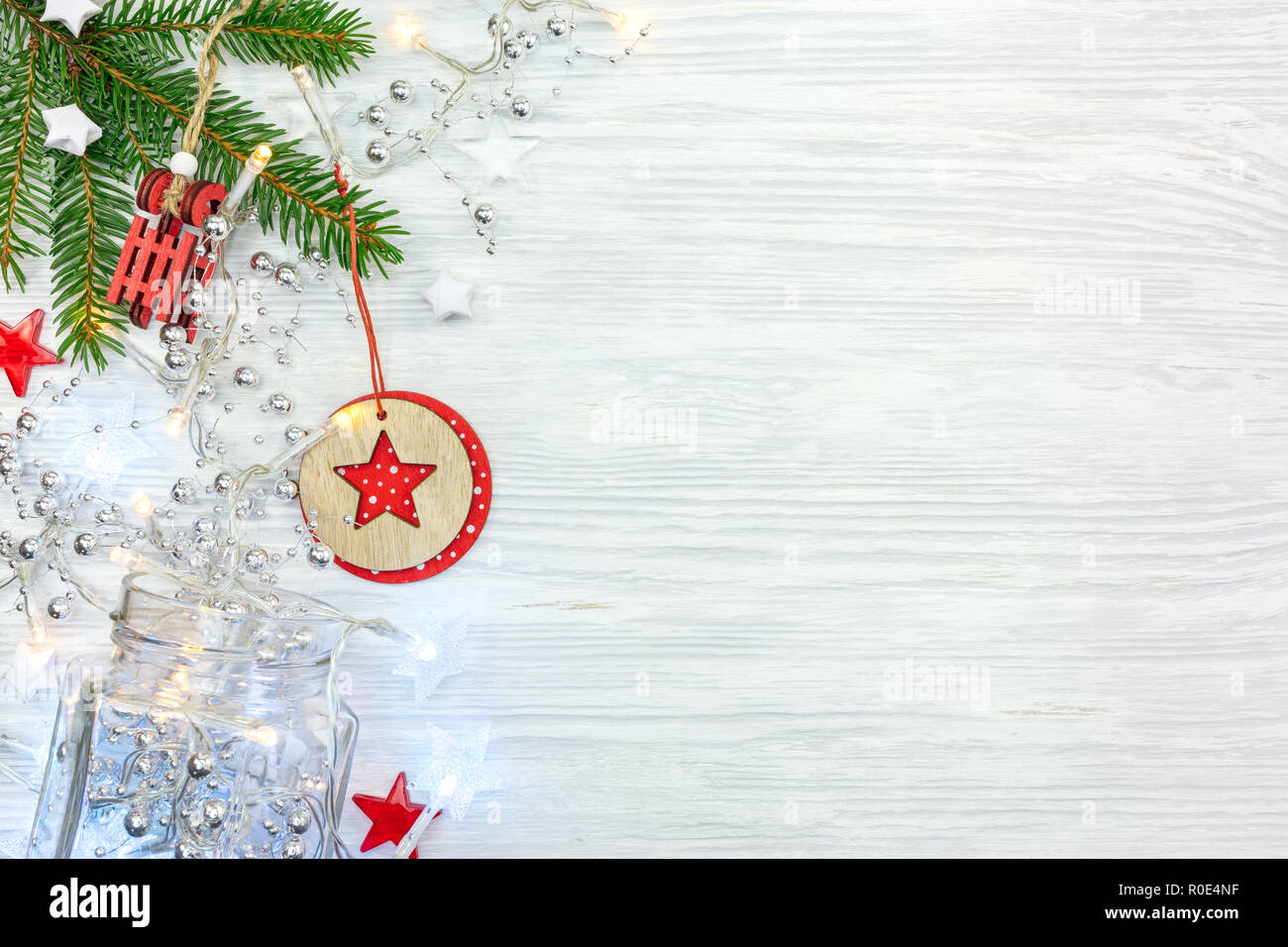 Grüne Tanne Baum mit Perlen verziert, Weihnachtsbeleuchtung, rot Holz Schlitten Spielzeug. Flache Ansicht Stockfoto