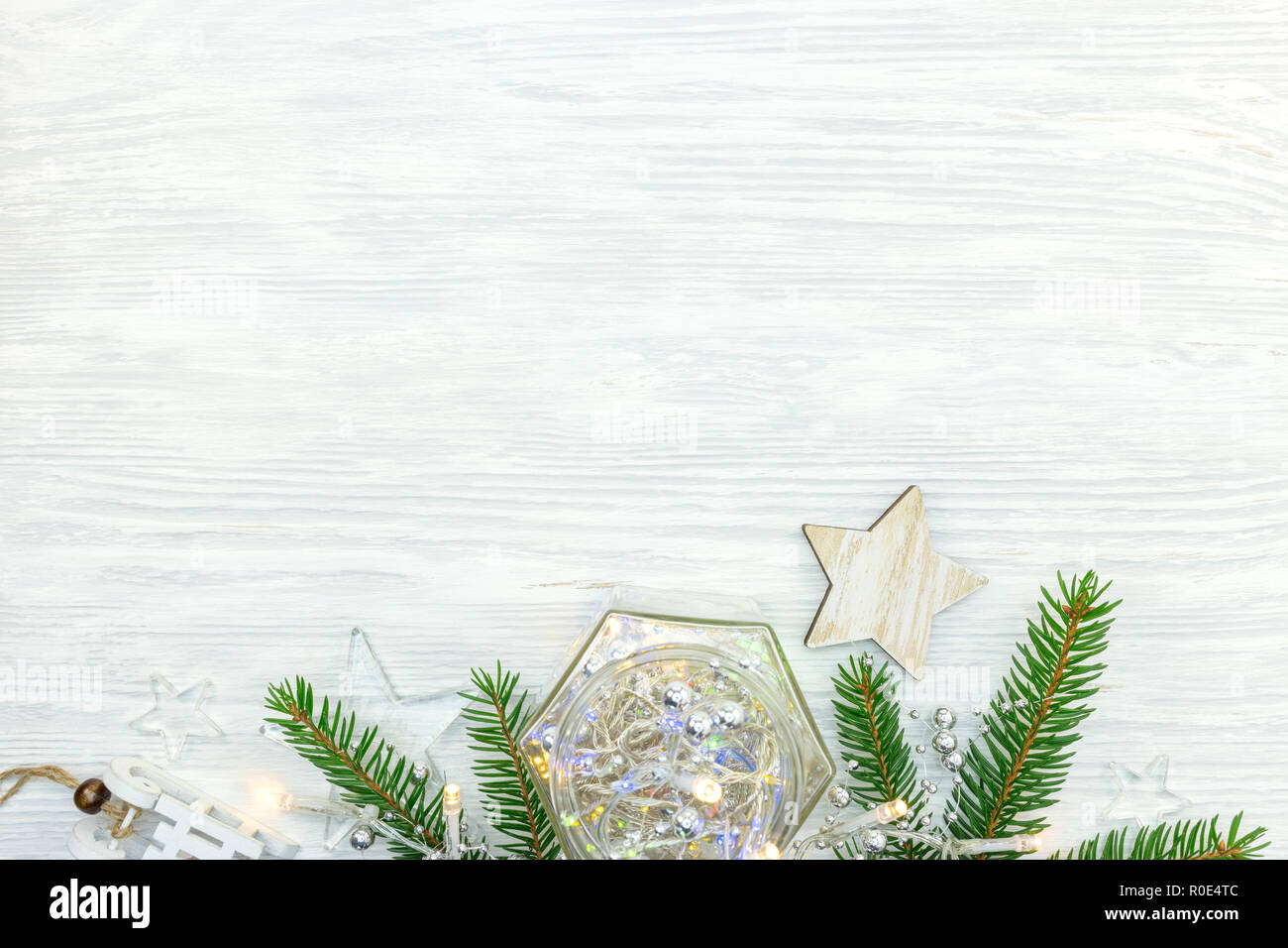 Holz und Glas weihnachten Sterne mit Lichtern Garland und Fir Tree Branch auf weißem Hintergrund Stockfoto