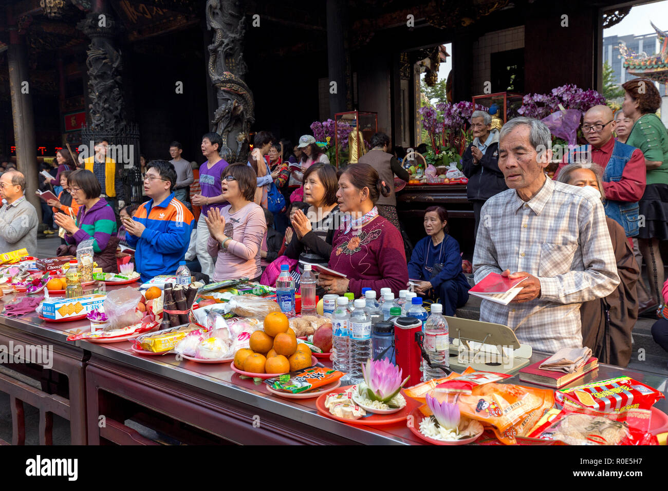 TAIPEI, Taiwan - 28. MÄRZ 2017: Menschen am Lungshan buddhistischen Tempel beten mit vielen Angeboten in Taipei, Taiwan Stockfoto