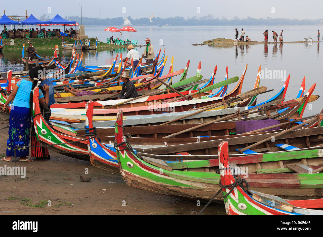 AMARAPURA, Myanmar, 18. JANUAR 2015: Einige Menschen in Burma schlägt eine Segeln in bunten Ruderboote auf dem Taungthaman See an der U Bein Brid Stockfoto
