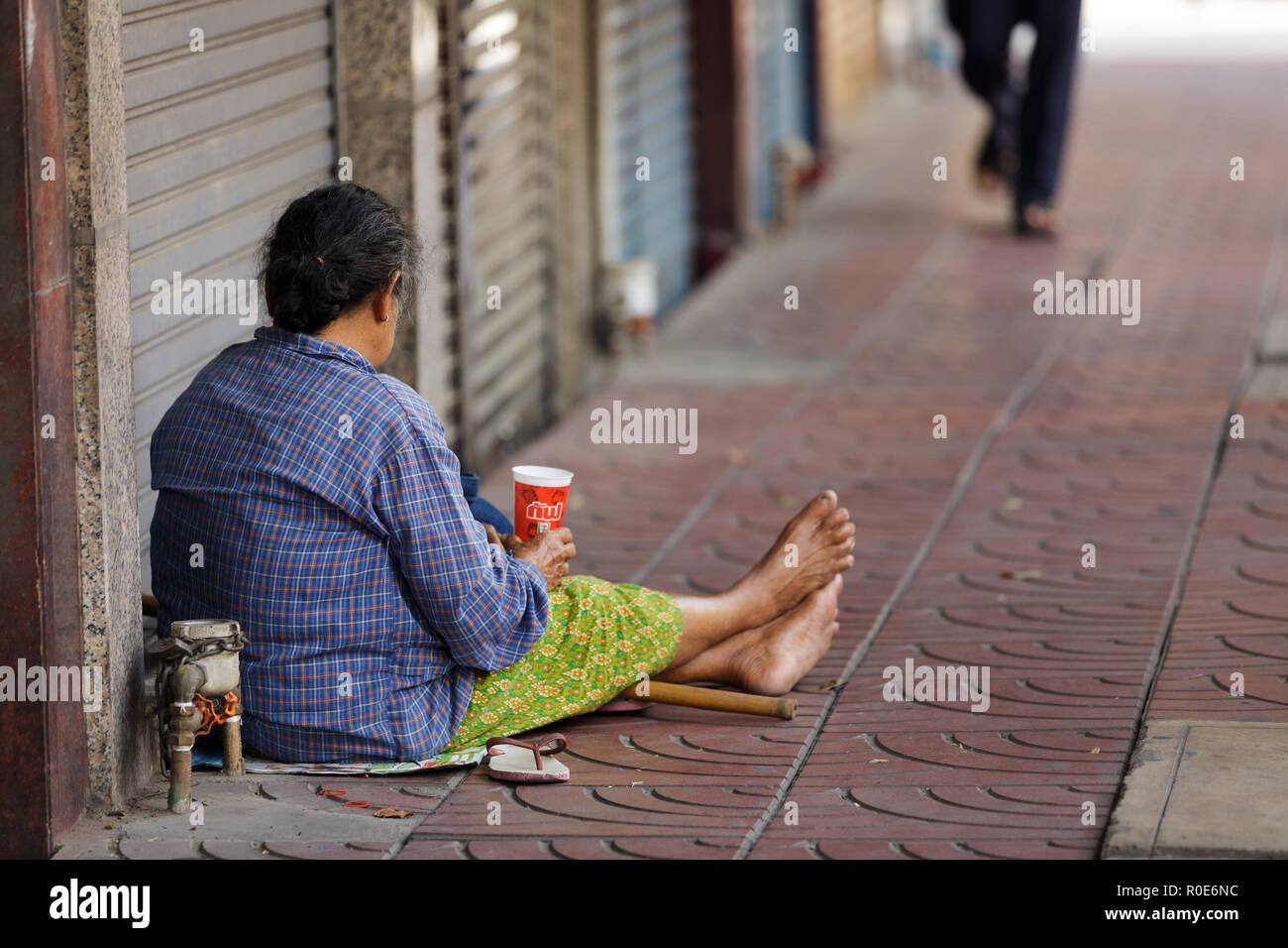 BANGKOK, THAILAND, Dezember 16: Thai Frau Bettler sitzen auf dem Bürgersteig in der Chinatown in Bangkok, Thailand, am 16. Dezember 2012 Stockfoto