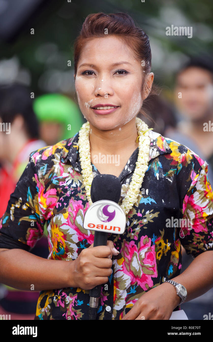 BANGKOK, THAILAND, 13. APRIL 2011: Ein TV-Reporter Frau Reden halten Ihr Mikrofon in der Silom Road über die Songkran buddhistische Festivals in Ba Stockfoto