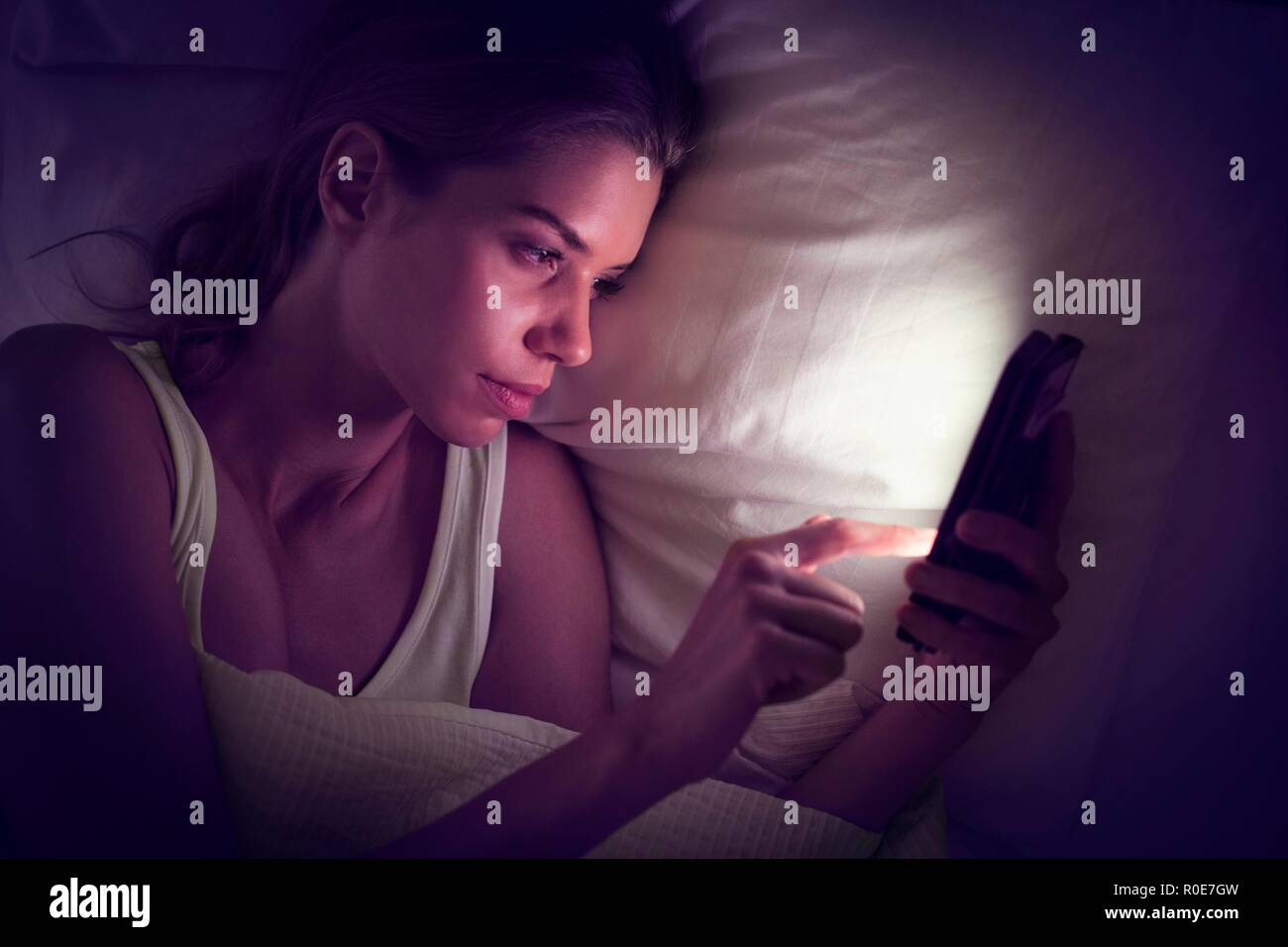 Junge Frau mit digitalen Tablet im Bett. Stockfoto