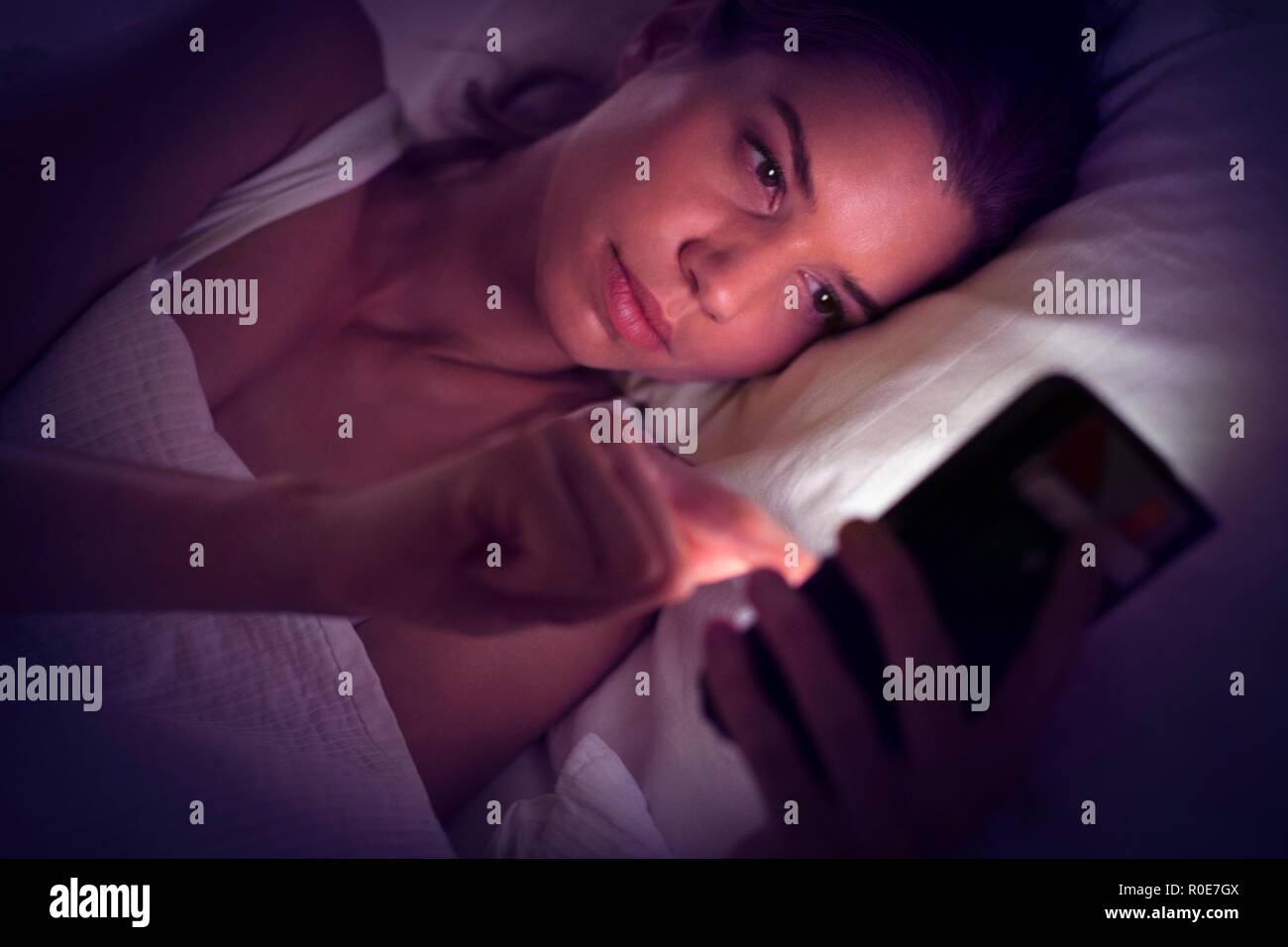Junge Frau mit digitalen Tablet im Bett. Stockfoto