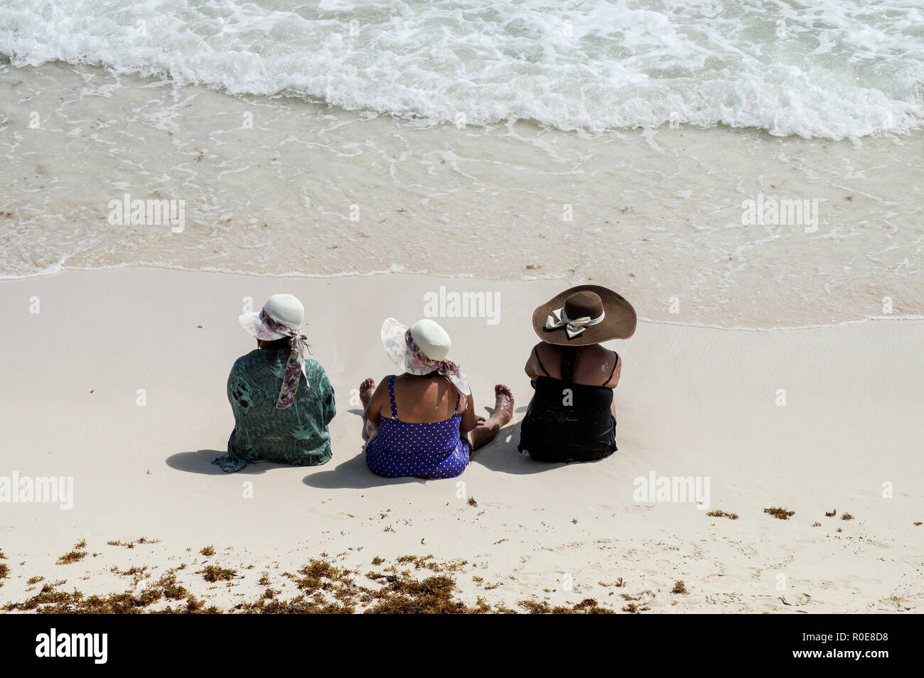 Drei fabelhafte Damen mittleren Alters in Badekleidung und schöne Hüte genießen Sie die Strände von Tulum, Mexiko Stockfoto